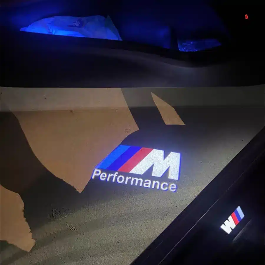 BMW M Sport Door Lights| BMW M Sport Door Lights Logo Projector Projection of "M Performance" logo with red, blue, and purple stripes on a dark floor, creating a sleek and modern automotive ambiance.